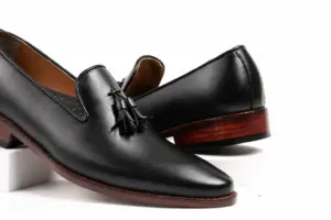 Close-up of black aniline leather grain, tassels and brown sole edges