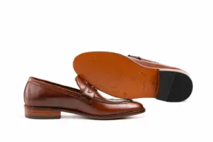Leather outsole and dark heel top lift of brown pull-up leather penny loafers