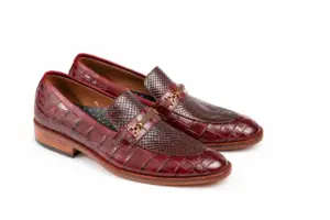Front-angle view of burgundy reptile-pattern horsebit loafers showing the contrasting vamp textures and hardware