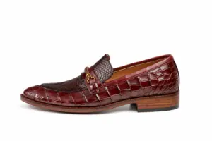 Side profile of burgundy reptile-pattern horsebit loafer showing the upper shape and sole edge