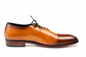 Inner side profile of cognac and brown croc-pattern panel cap-toe Oxford shoes showing the leather finish and heel proportions