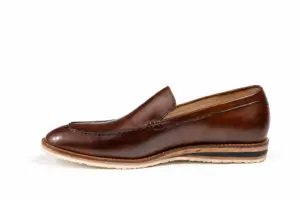 Inner profile of a brown apron-toe loafer showing the rounded forepart and cream sole