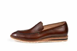 Outer profile of a dark brown leather loafer with brown, black and cream sole bands
