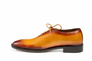 Inner profile of a tan wholecut Oxford showing the continuous leather upper and darker edges