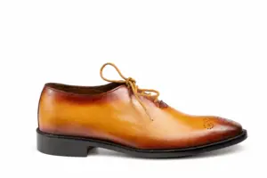 Outer profile of a tan burnished wholecut Oxford with a dark sole edge and low heel