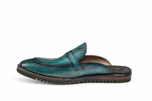 Inner side profile of teal patina buckle mules with Vibram soles showing the leather finish and heel proportions