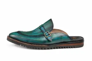 Outer side profile of teal patina buckle mules with Vibram soles showing the upper shape and sole edge
