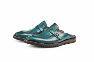 Pair of teal patina buckle mules with Vibram soles showing the forepart and sole profile
