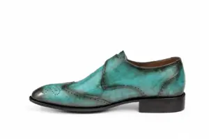 Inner side profile of turquoise patina wingtip single monk strap shoes showing the leather finish and heel proportions