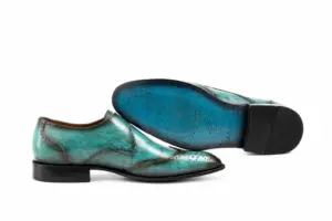 Leather outsole and dark heel top lift of turquoise patina wingtip single monk strap shoes