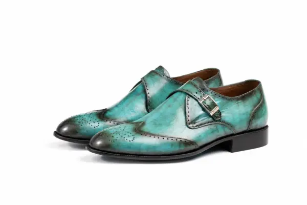 Pair of turquoise patina wingtip single monk strap shoes showing the forepart and sole profile