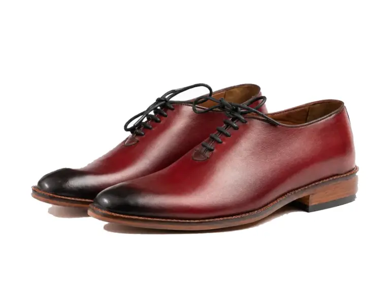 Three-quarter pair of oxblood wholecut Oxfords with black burnished toes and brown sole edges