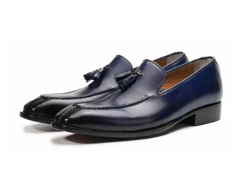 Pair of deep purple-black patina tassel loafers showing tapered apron toes
