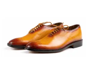 Pair of tan burnished wholecut Oxfords with darker toes and decorative medallions