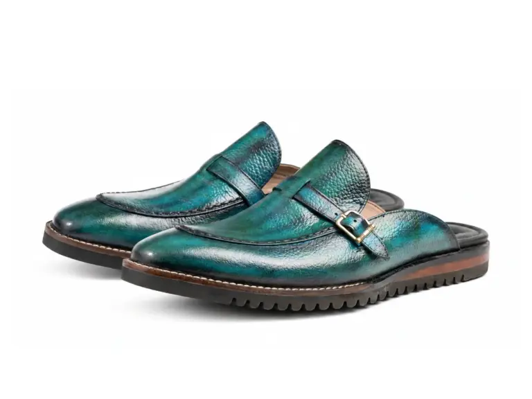 Pair of teal patina buckle mules with Vibram soles showing the forepart and sole profile